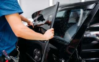 technician adding tint to car window